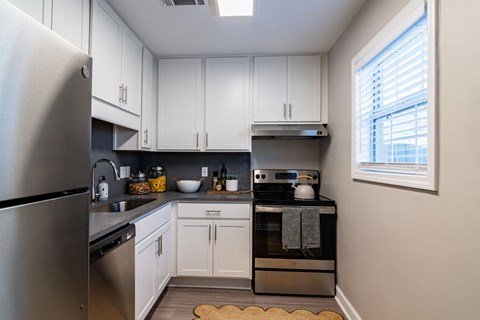 a kitchen with stainless steel appliances and white cabinets