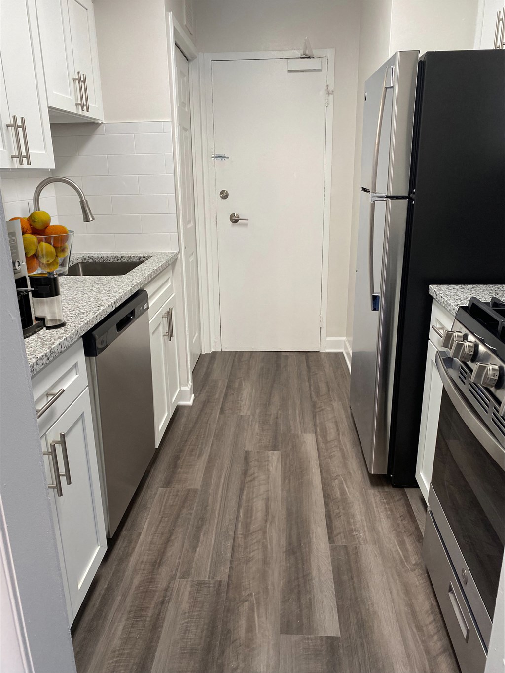 Renovated Kitchen with stainless steel appliances and granite countertops at Wellington Apartments, Arlington