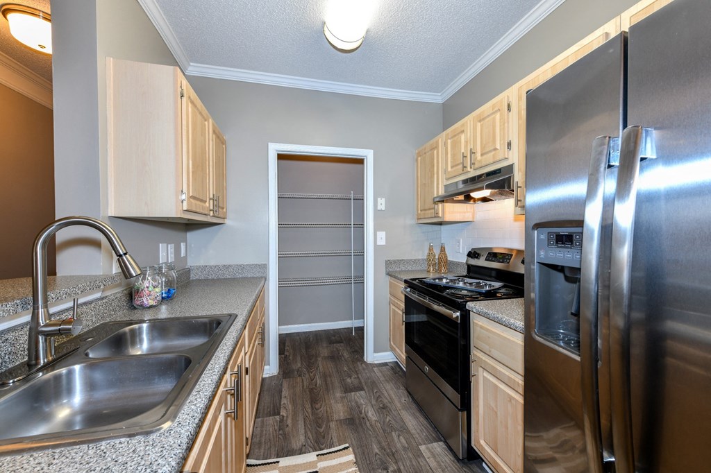 Kitchen with stainless steel appliances and wood cabinets at Elme Eagles Landing in Stockbridge, GA