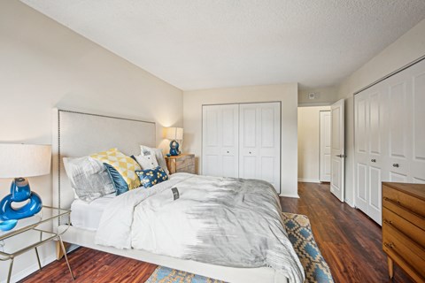 A bedroom with a bed, nightstand, and a lamp at Riverside Apartments, Alexandria, Virginia