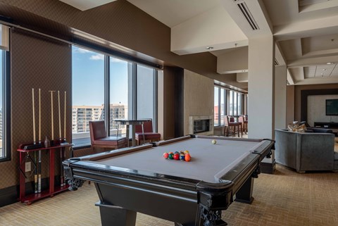 a pool table in a room with large windows