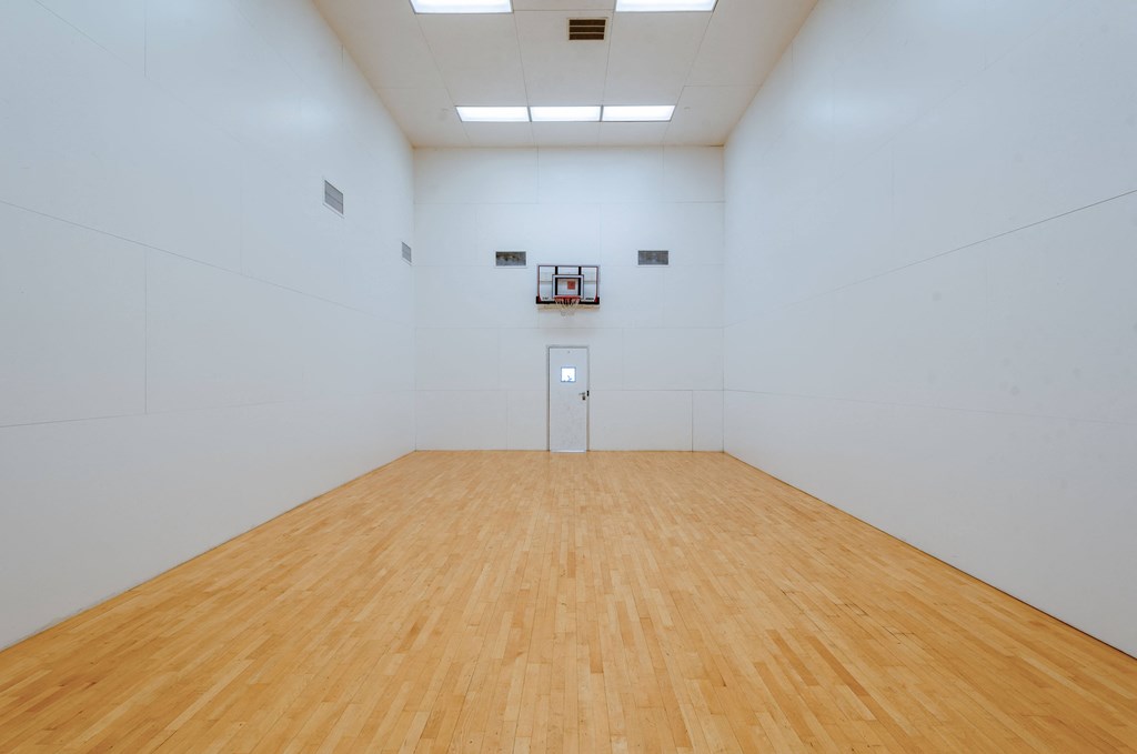 a large white room with a wooden floor and a white wall