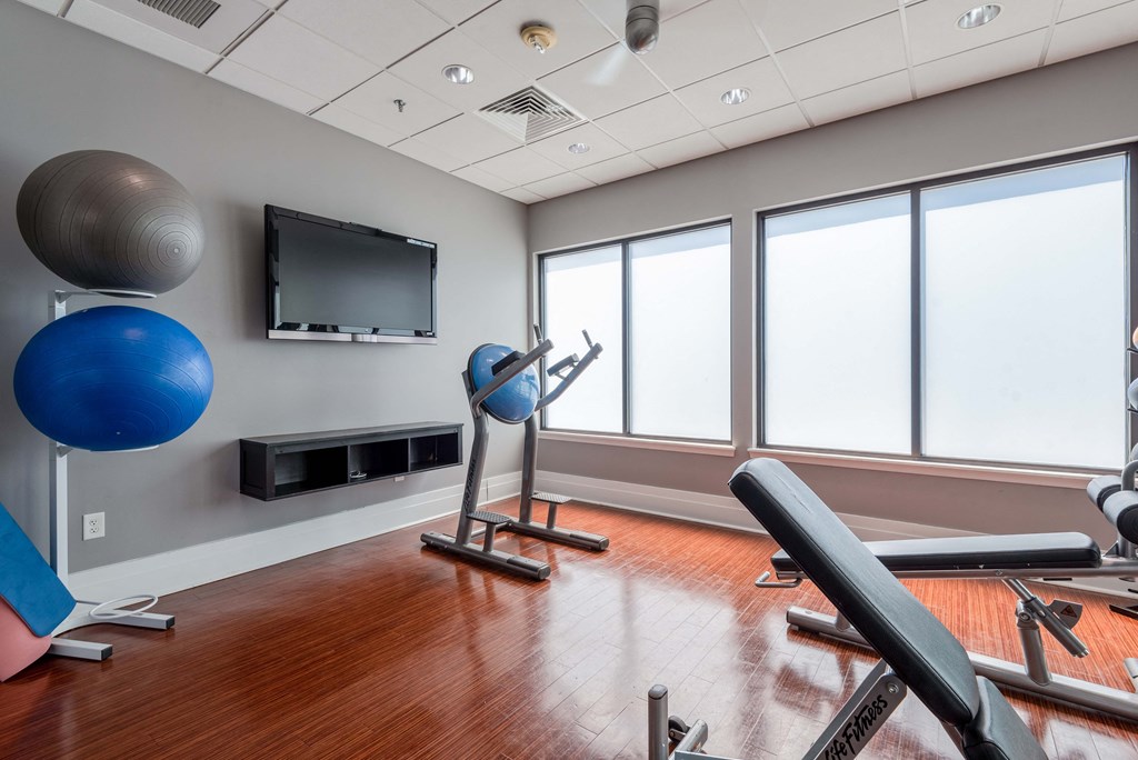 a fitness room with exercise equipment and a tv