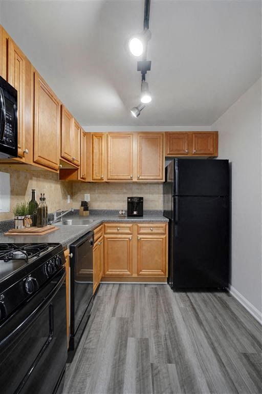Kitchen with black appliances and wood cabinets at Roosevelt Towers Apartments, Falls Church, Virginia