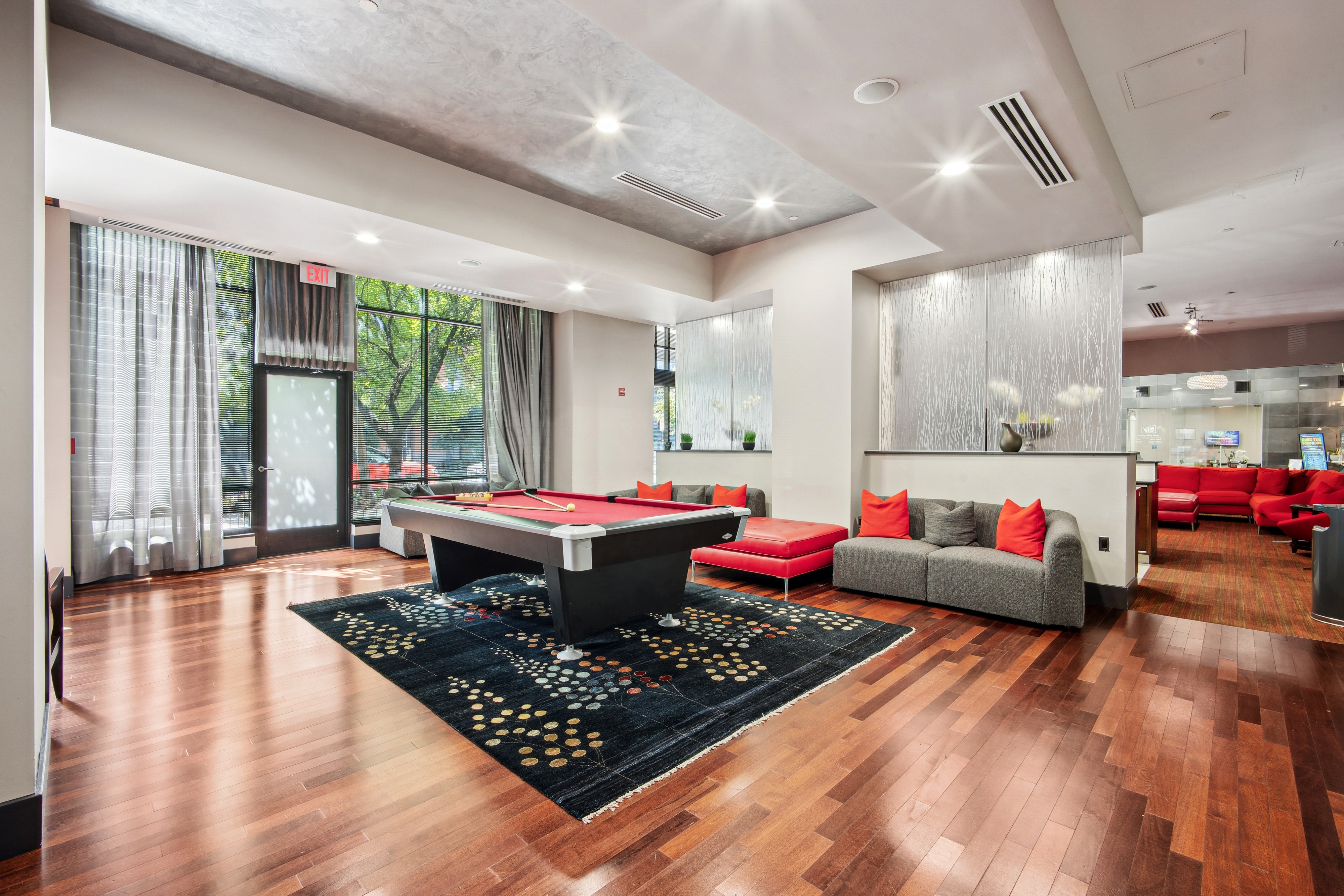 A living room with a black rug and wooden floors.