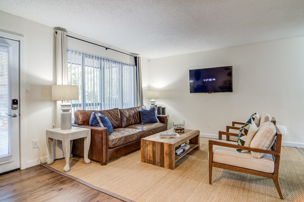 a living room with a couch and a chair and a tv appliances at Elme Cumberland Apartments, Smyrna, Georgia