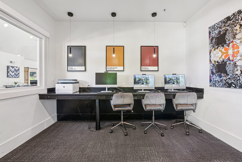 A modern office with a long desk and four chairs at Elme Marietta Apartments, Marietta, GA
