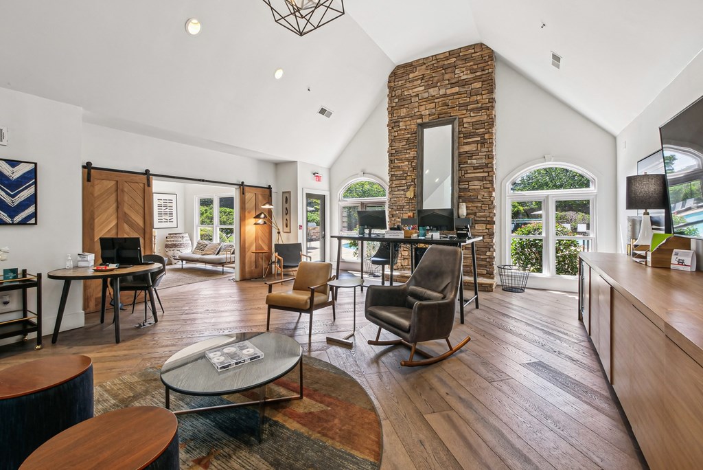 A living room with a brick fireplace and a large window at Elme Marietta Apartments, Marietta, GA