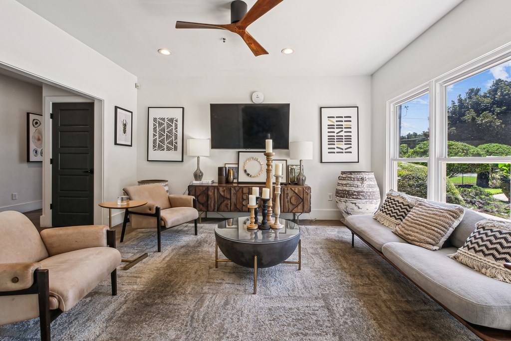 A living room with a large couch, a coffee table, and a ceiling fan  at Elme Marietta Apartments, Marietta, GA at Elme Marietta Apartments, Marietta, GA