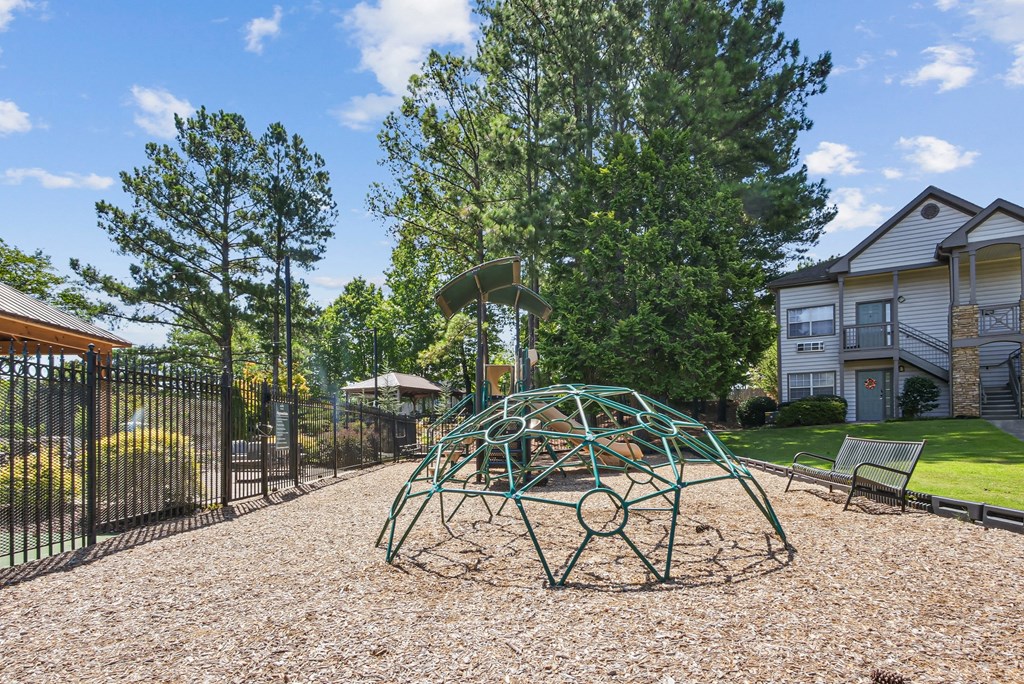 A playground with a green swing set at Elme Marietta Apartments, Marietta, GA