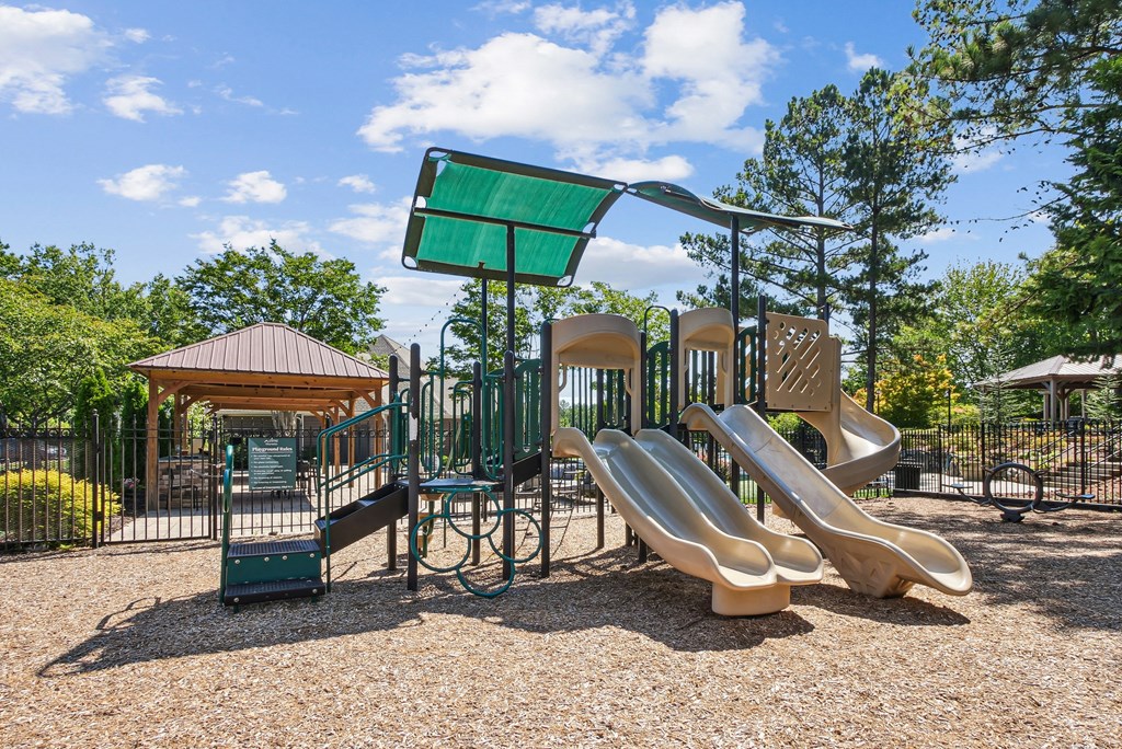A playground with a green sign and a slide at Elme Marietta Apartments, Marietta, GA