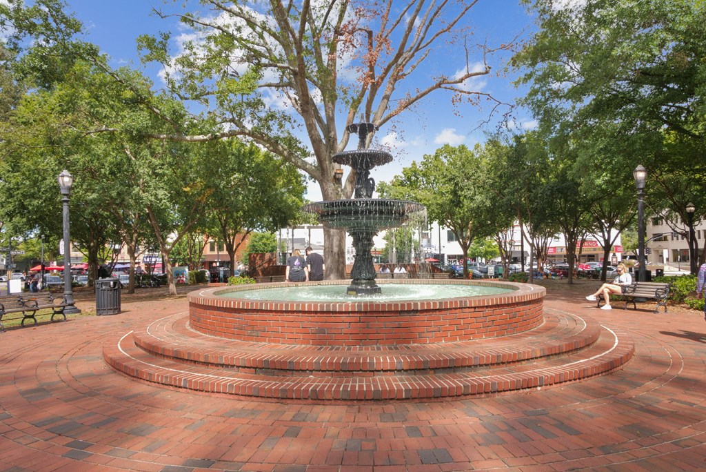 A fountain in the middle of a brick plaza surrounded by trees  at Elme Marietta Apartments, Marietta, GA