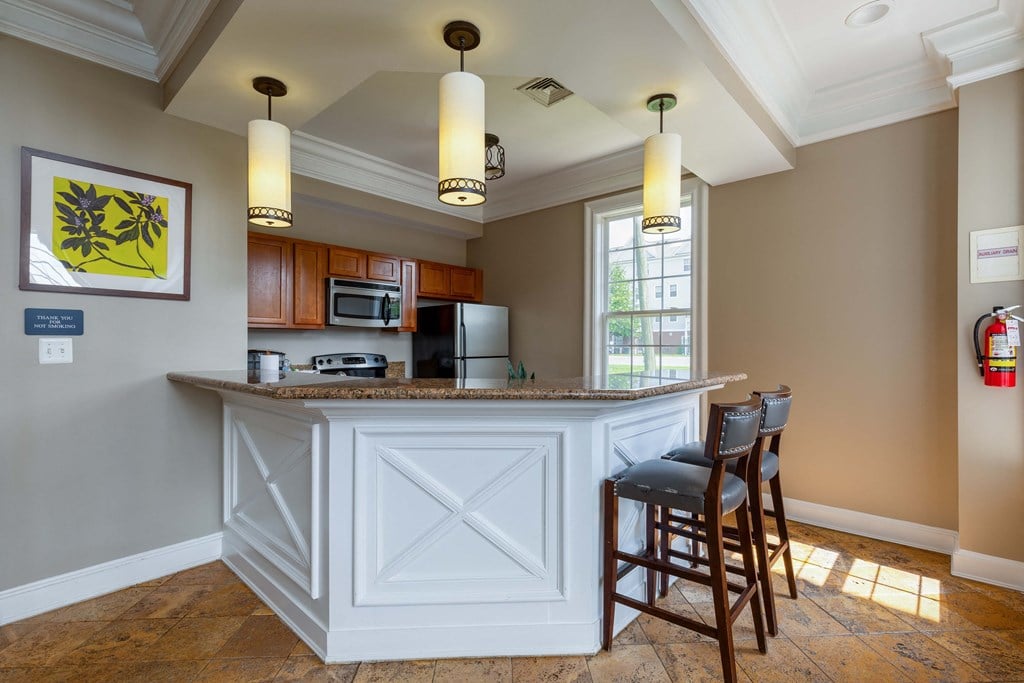 a kitchen with a large island with chairs and a counter