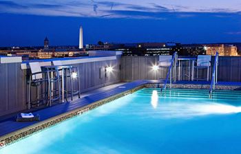 a rooftop pool with a city skyline in the background at Yale West, Washington, DC