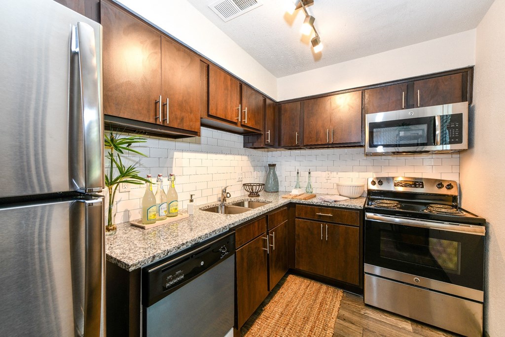 Kitchen with stainless steel appliances and granite countertops at Elme Sandy Springs Apartments, Atlanta, GA