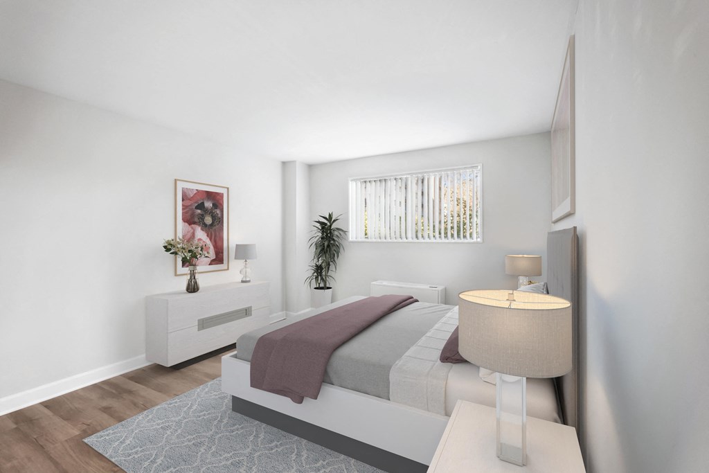 a bedroom with white walls and a bed with a purple blanket at Roosevelt Towers, Falls Church, VA