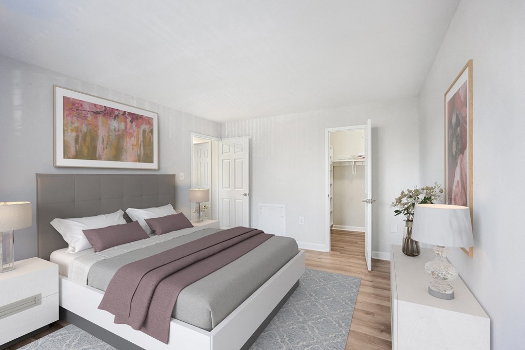 a bedroom with white walls and a bed with purple pillows at Roosevelt Towers, Falls Church, VA