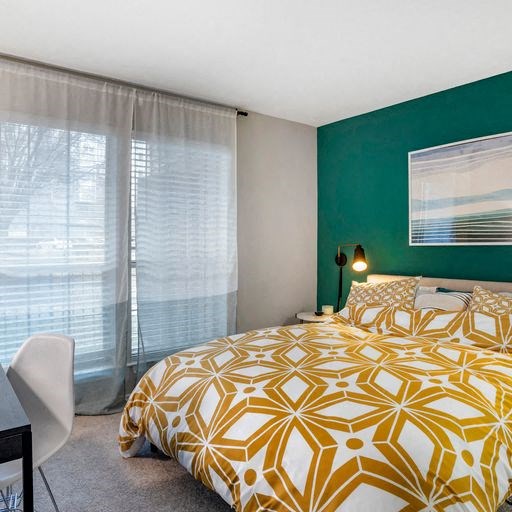a bedroom with a green wall and a yellow and white bedspread at Elme Alexandria, Alexandria