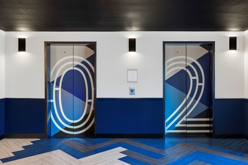 Two blue and white elevators in a lobby at Elme Alexandria, Alexandria, 22304