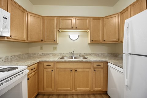 A kitchen with wooden cabinets and a white refrigerator.