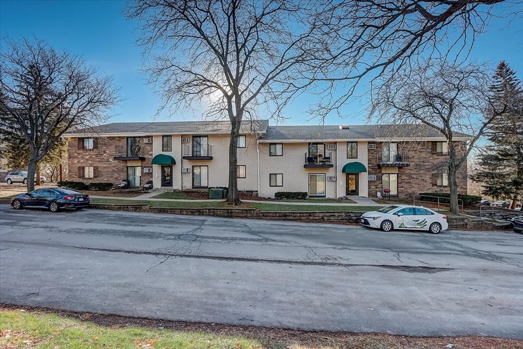 a large apartment building with cars parked in front of it
