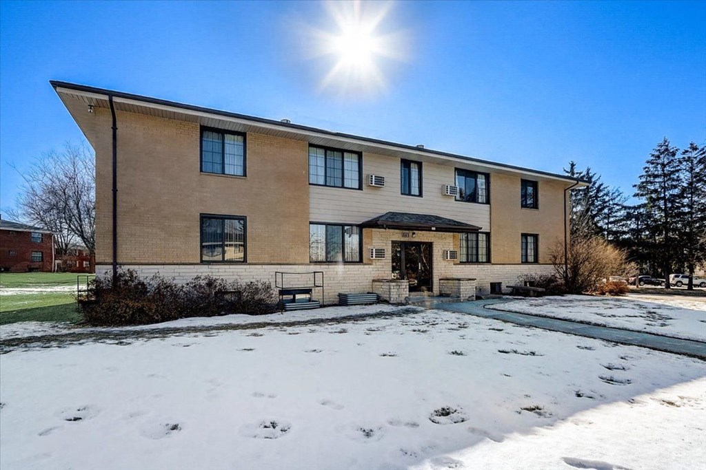 the front of a brick house in the snow