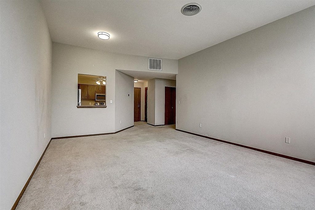 an empty living room with white walls and carpet