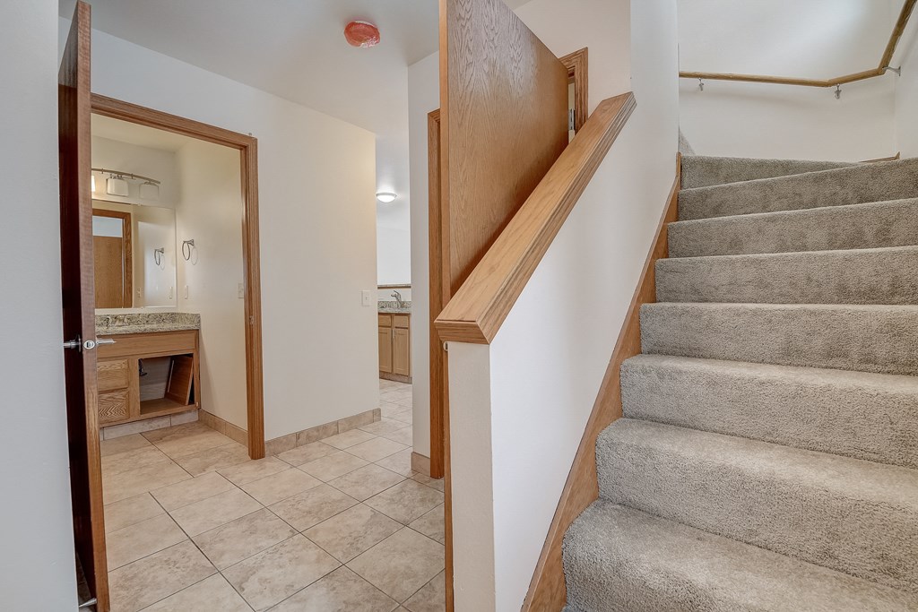 a staircase in a house with a door to a bathroom and a kitchen