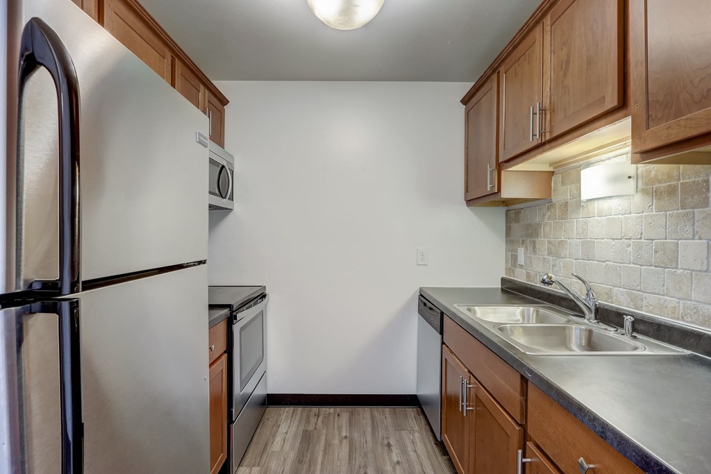 a kitchen with wooden cabinets and stainless steel appliances