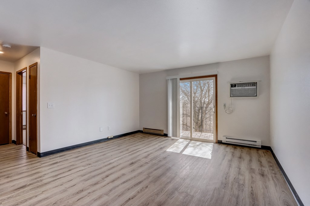 a bedroom with hardwood floors and white walls
