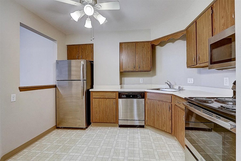 a kitchen with stainless steel appliances and wooden cabinets