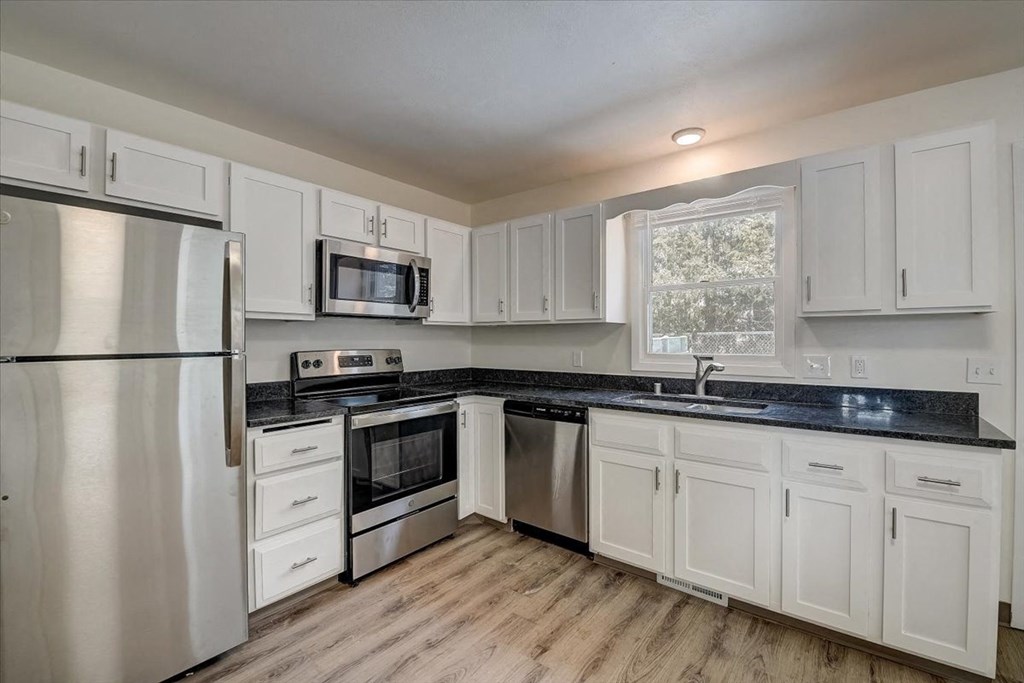 a kitchen with white cabinets and stainless steel appliances