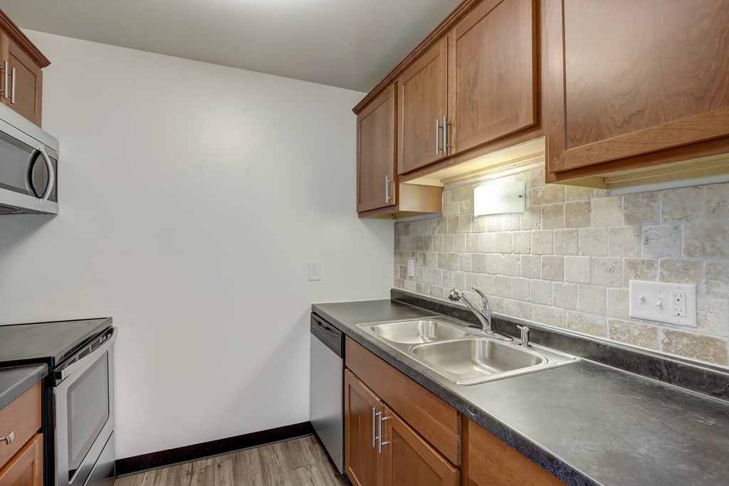 a kitchen with wooden cabinets and stainless steel appliances