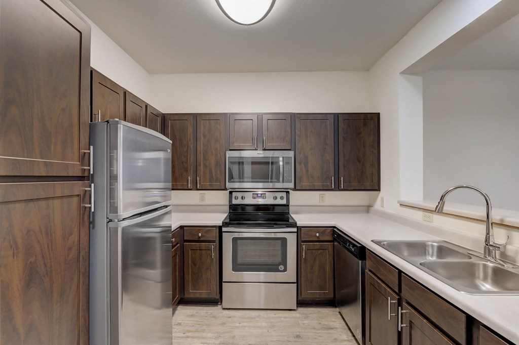 a kitchen with stainless steel appliances and wooden cabinets