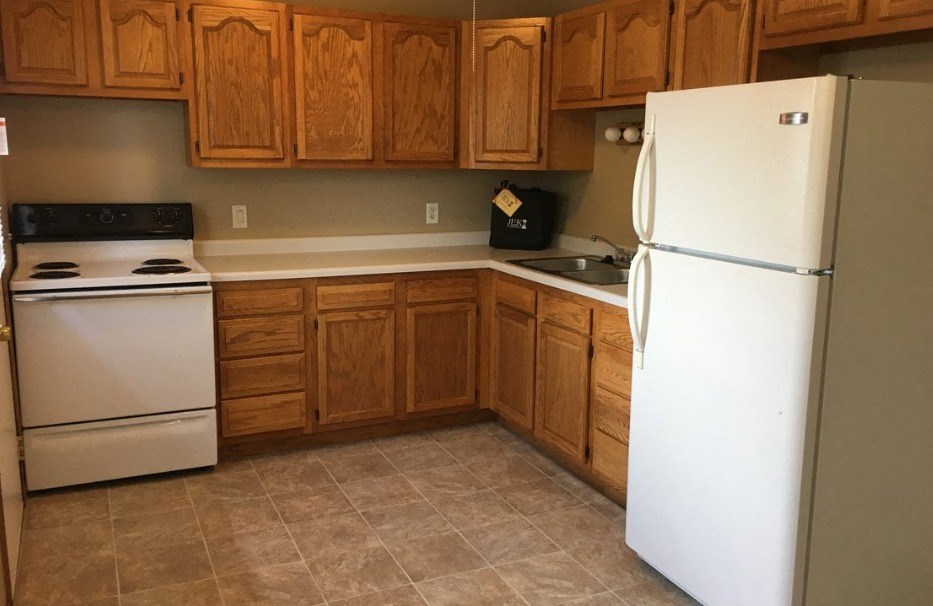 a kitchen with white appliances and wooden cabinets