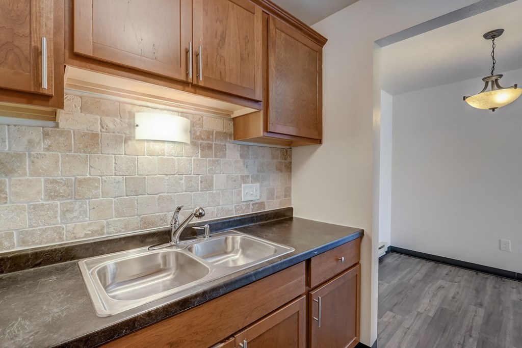 a kitchen with wood cabinets and a sink