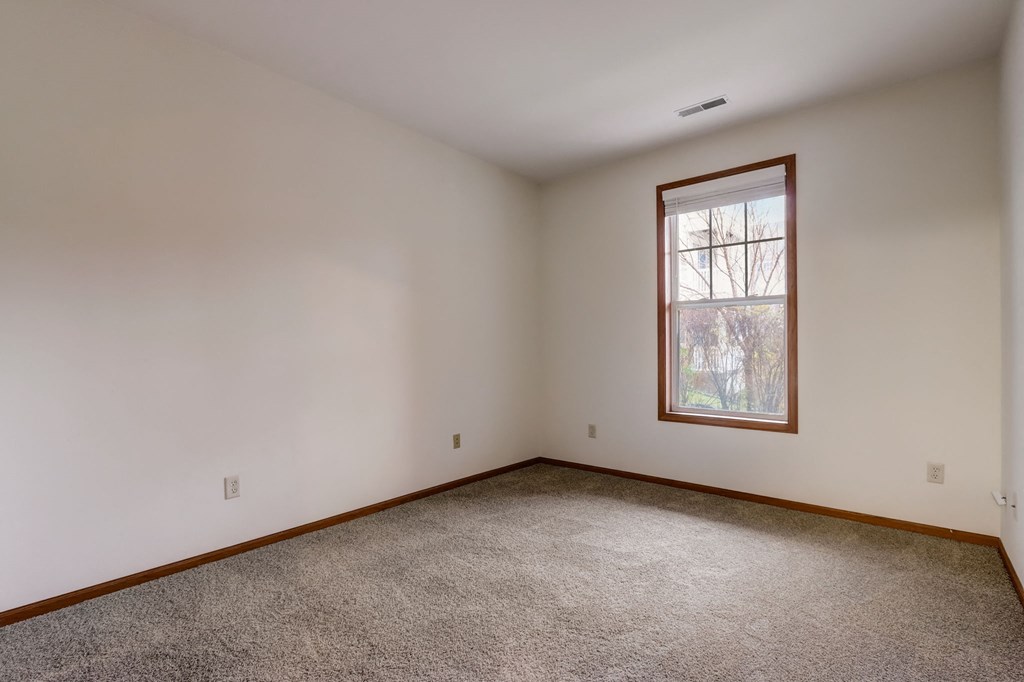 a room with white walls and a window and a carpet