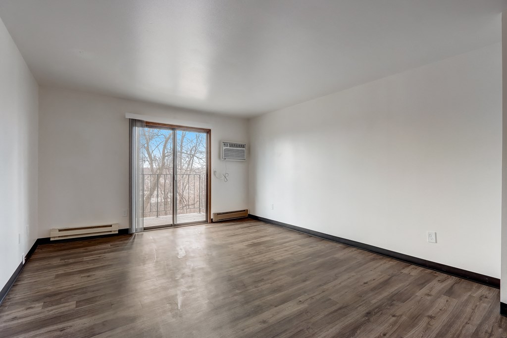 a bedroom with hardwood floors and white walls