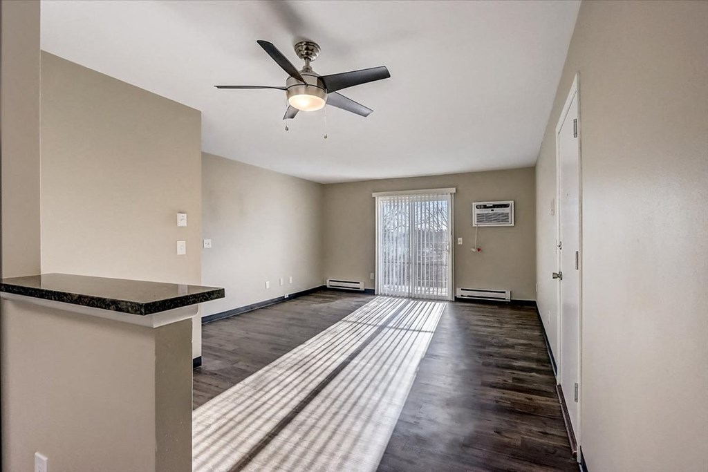 an empty living room with a ceiling fan