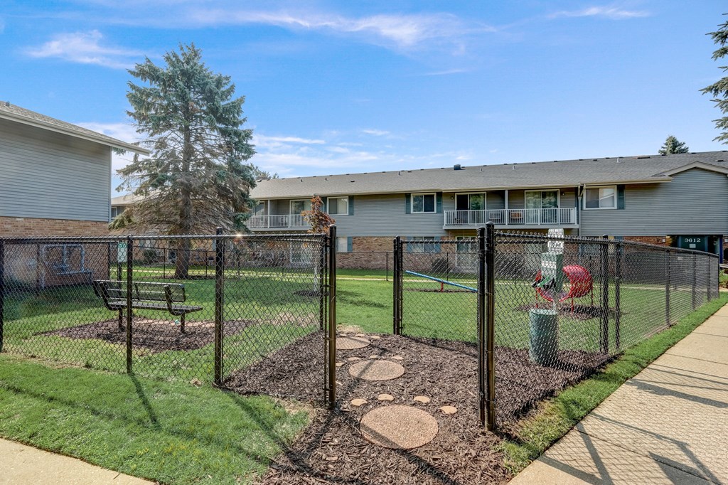 a fenced in yard with a house in the background