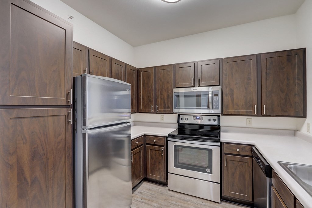 a kitchen with stainless steel appliances and wooden cabinets