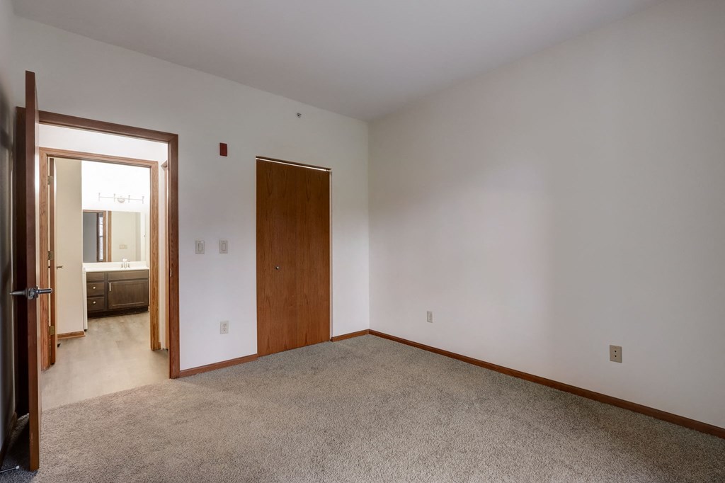 a living room with carpet and a door to a bathroom