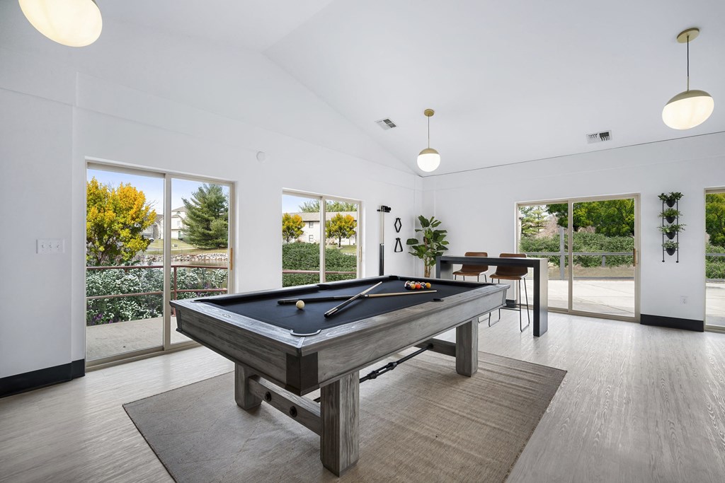 a pool table in a living room with a view of a dining room