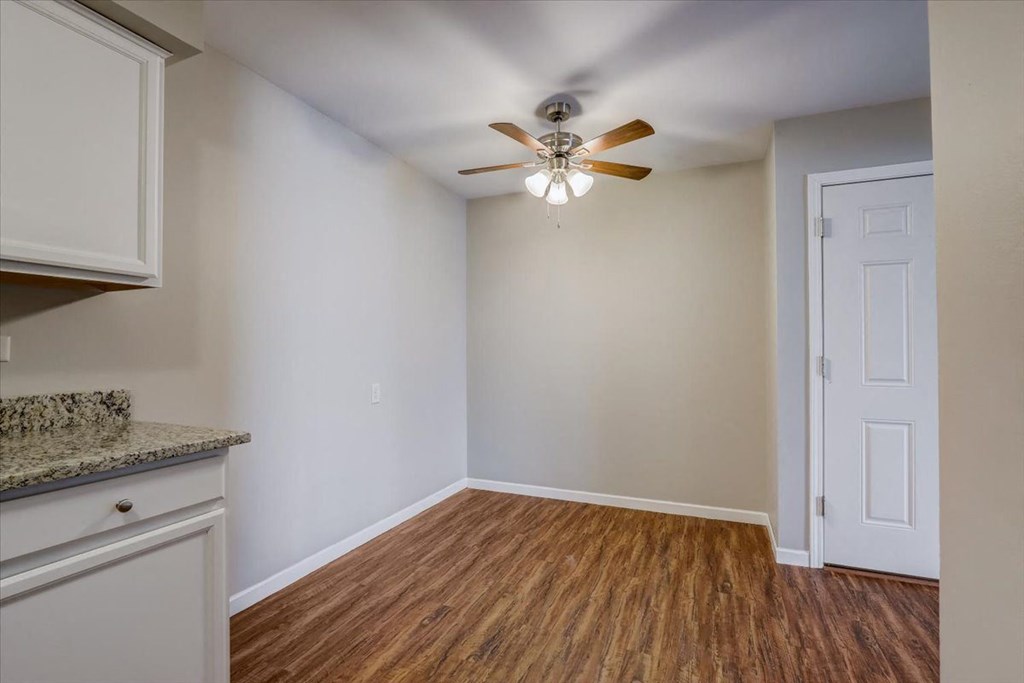 an empty living room with a ceiling fan