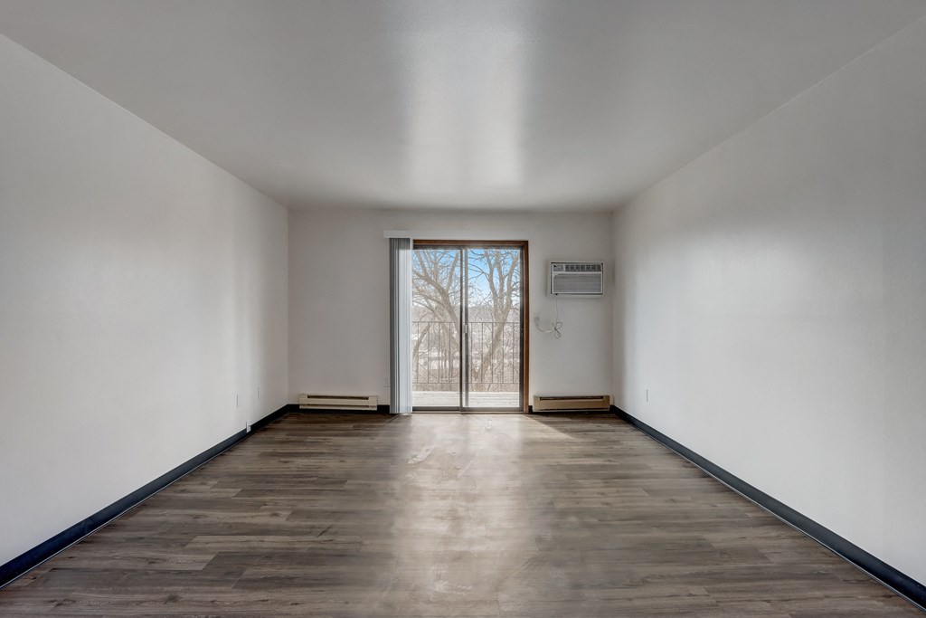 a bedroom with hardwood floors and white walls