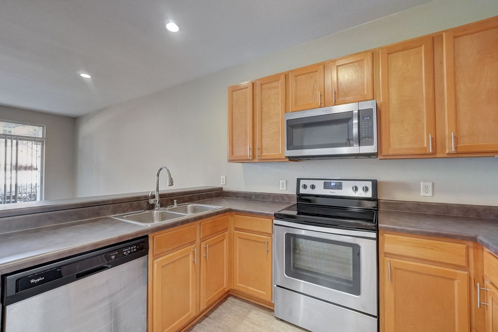 the kitchen has stainless steel appliances and wood cabinets