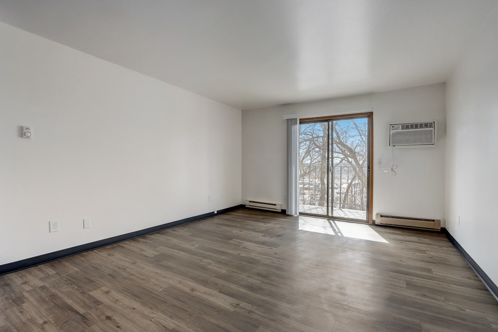 a bedroom with hardwood floors and white walls