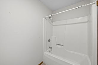a bathroom with a white tub and a white shower curtain