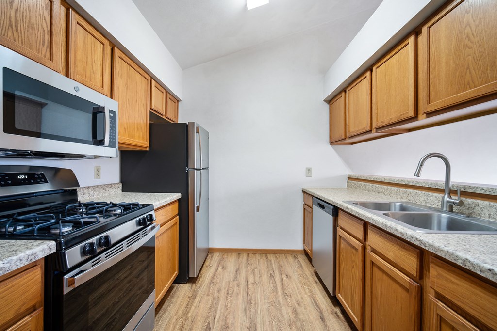 a kitchen with wooden cabinets and stainless steel appliances