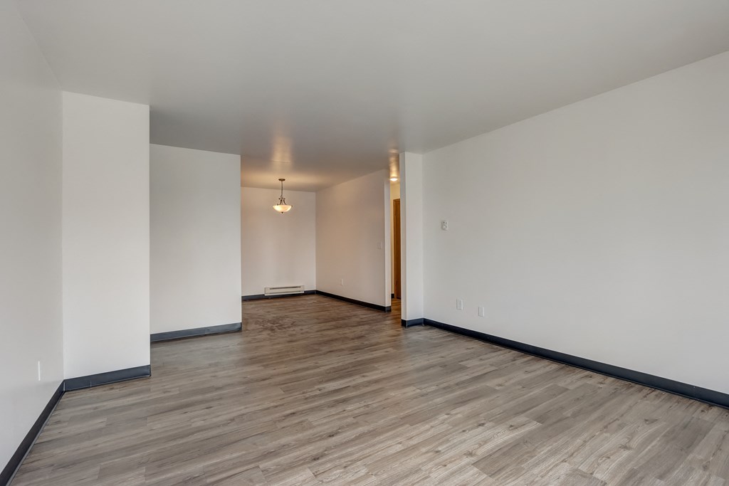 a bedroom with hardwood floors and white walls